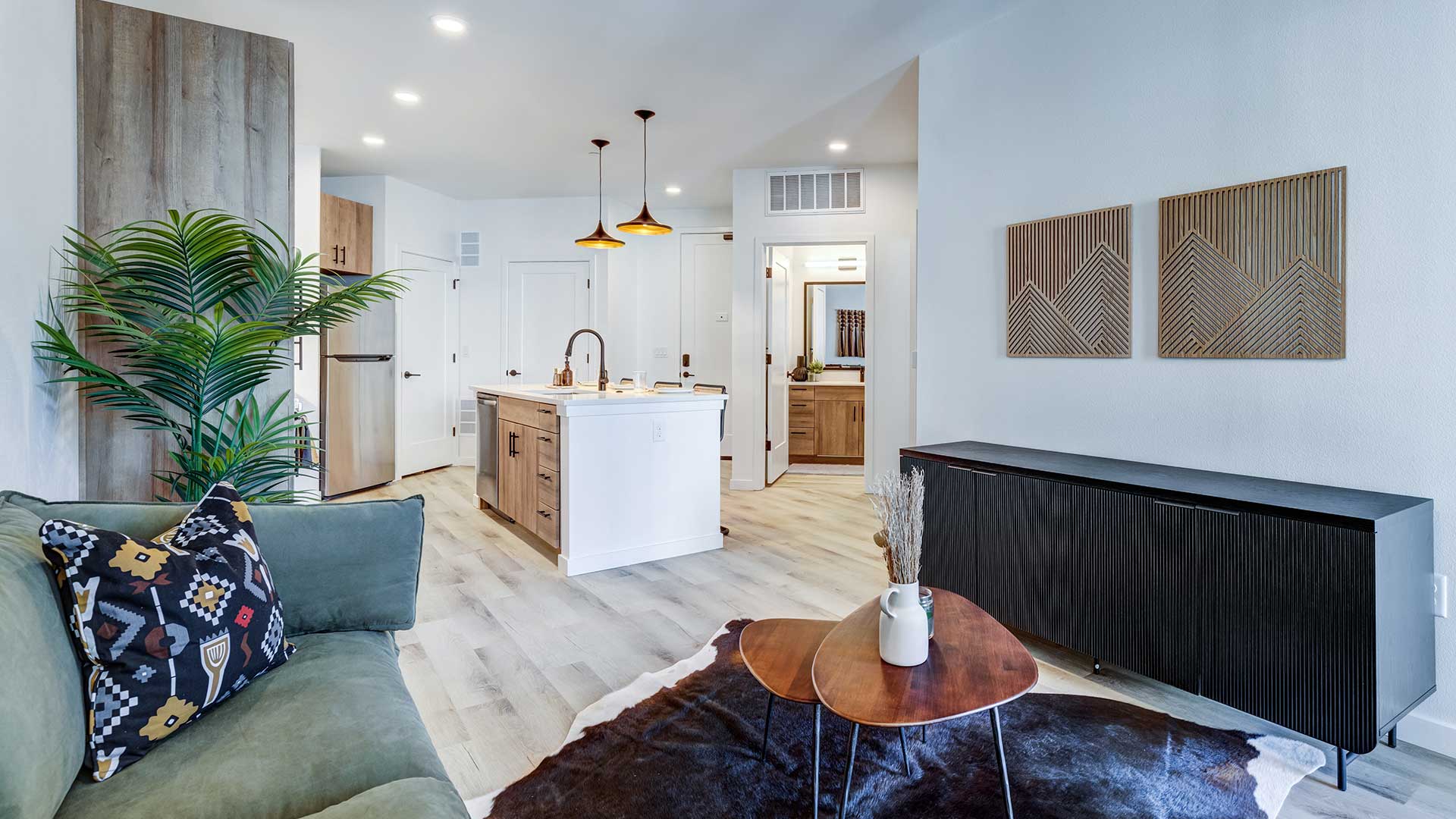 Modern open-concept apartment interior with kitchen island, living area, and contemporary finishes at Tempo at Nine Mile.