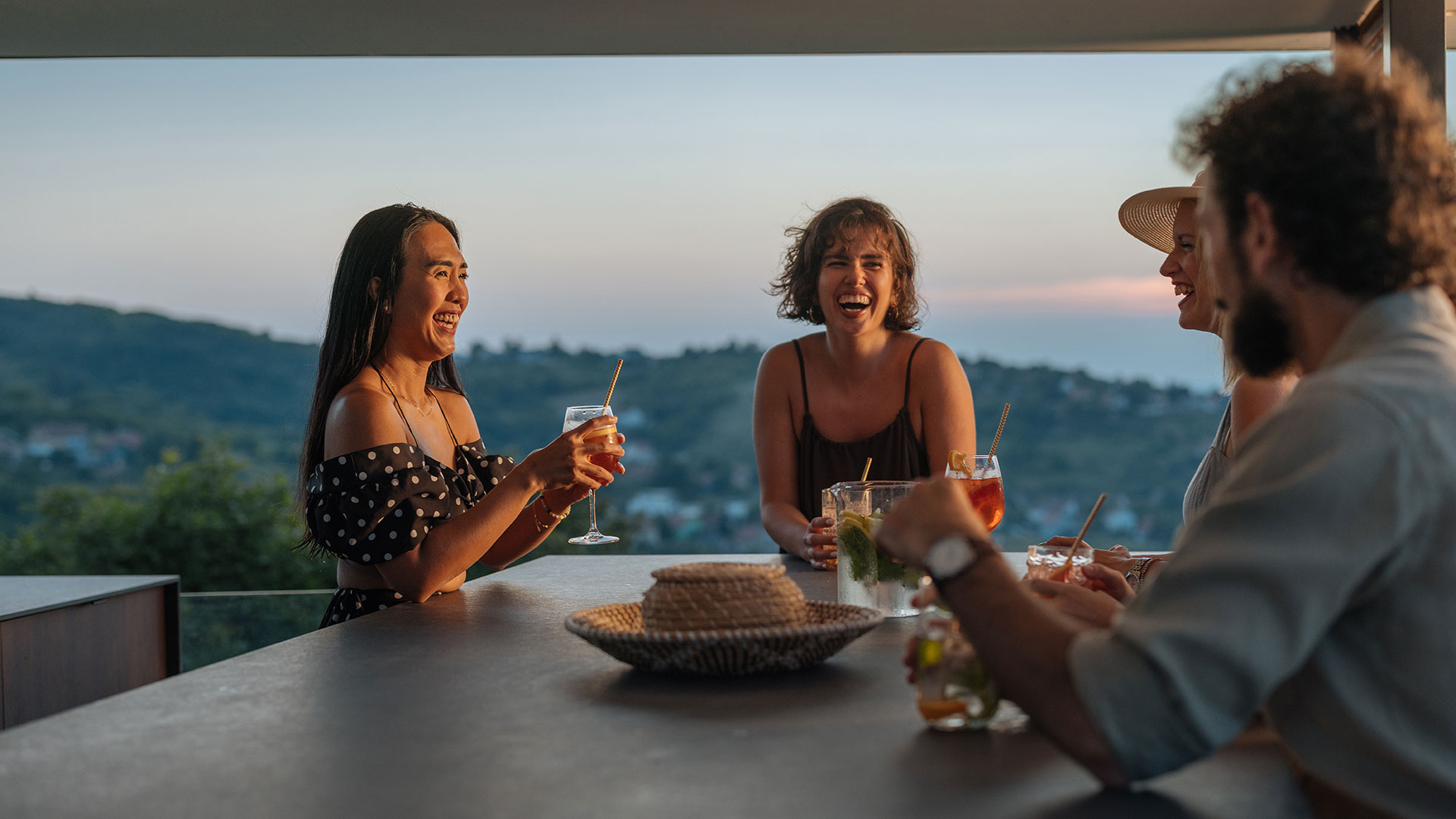 Friends enjoying drinks and conversation at a modern rooftop patio near Denver Tech Center.